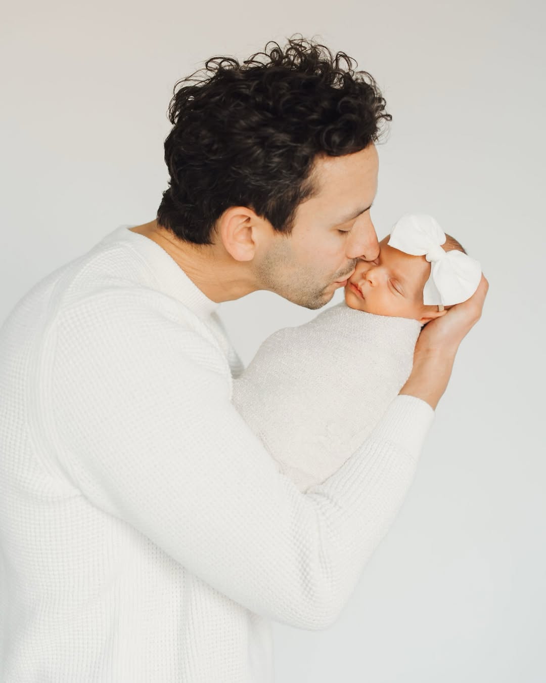 Father kissing newborn baby