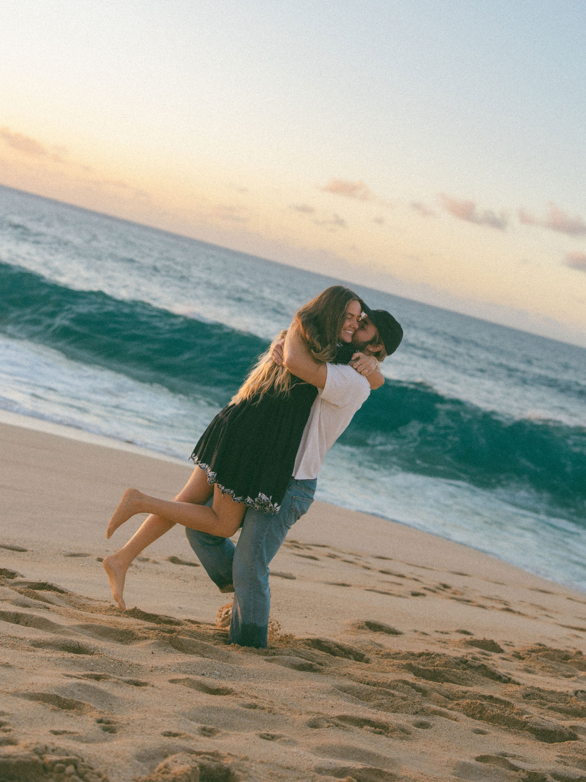 Couple embracing on beach at sunset