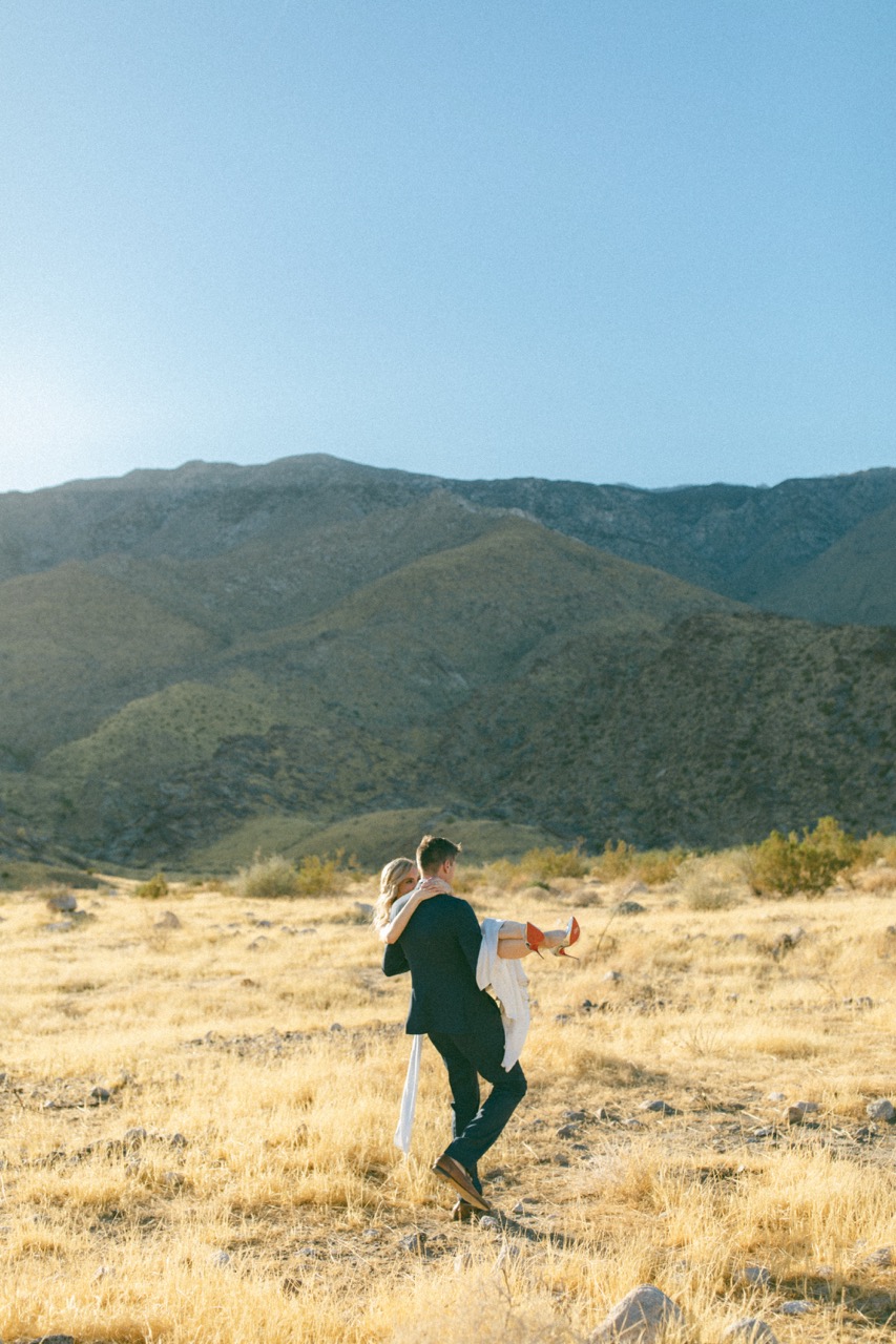 Couple in desert landscape with mountain backdrop