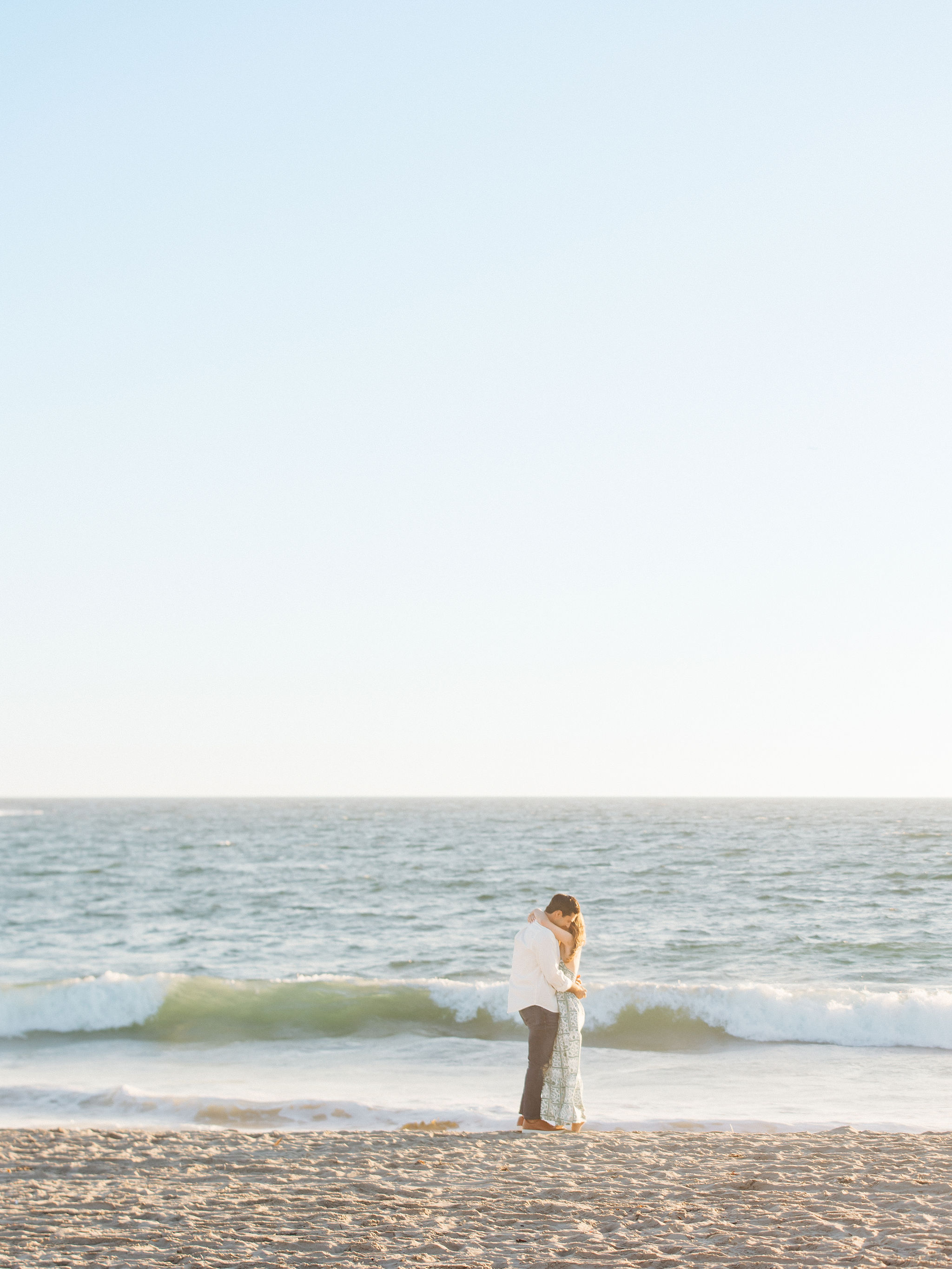Couple embracing at the ocean at golden hour